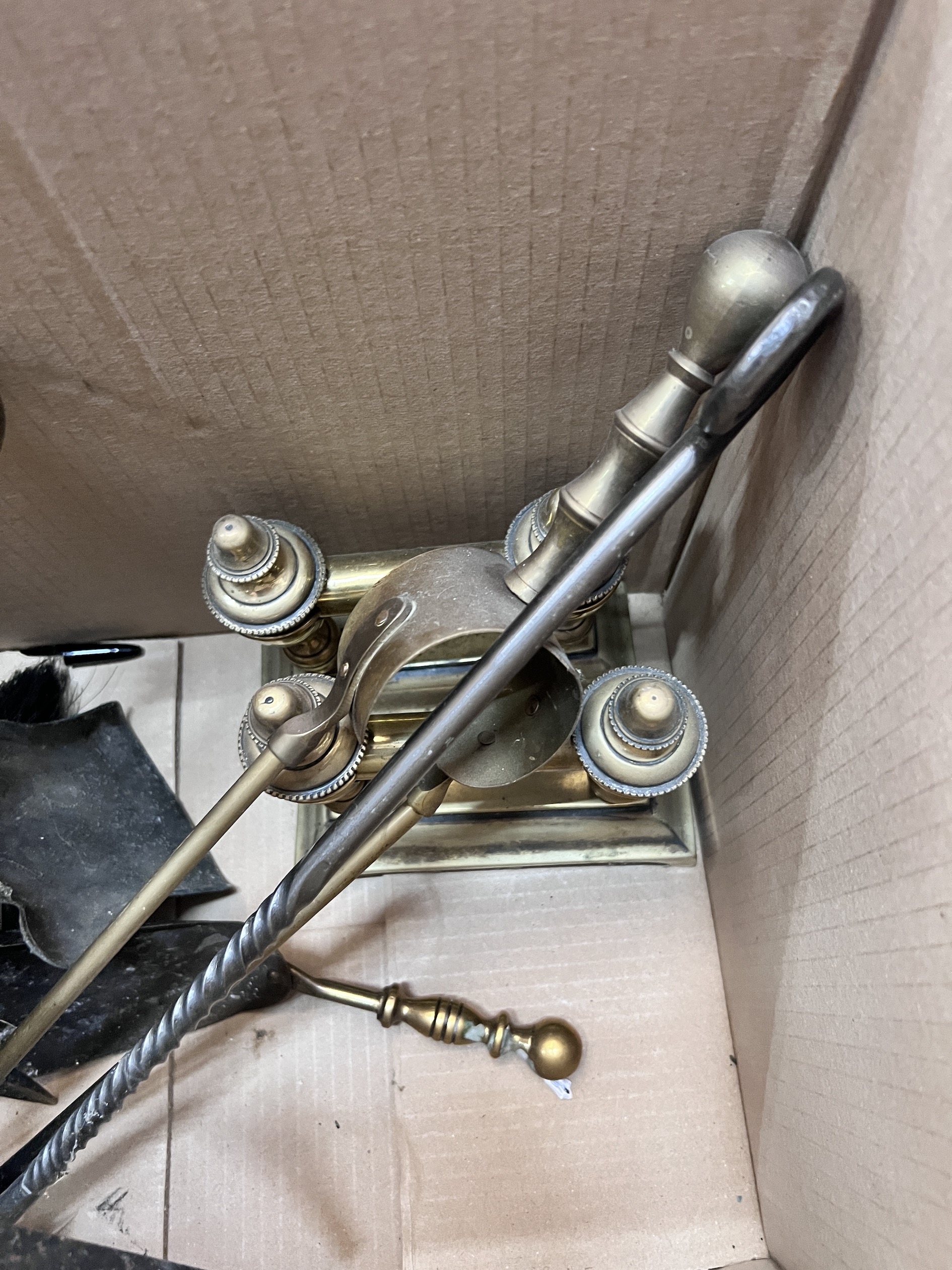 A collection of assorted fire implements and a pair of brass fire dogs